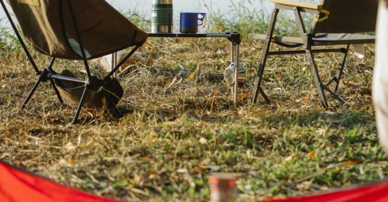 Campsites - Unfolded camping chairs and tent placed on grassy lake shore in peaceful summer nature