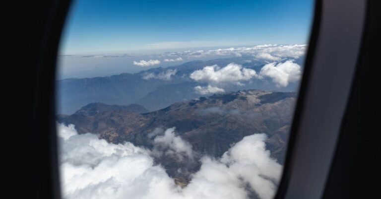 Trip - Mountains and Clouds Outside of an Airplane Window