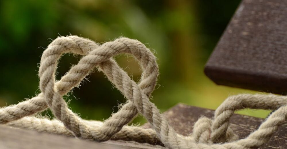 Knots - Brown Rope Tangled and Formed Into Heart Shape on Brown Wooden Rail